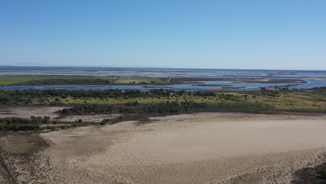 Sandy-beach-vineyards-crops-and-salt-evaporation-pond-aerial-shot-sunny-day
